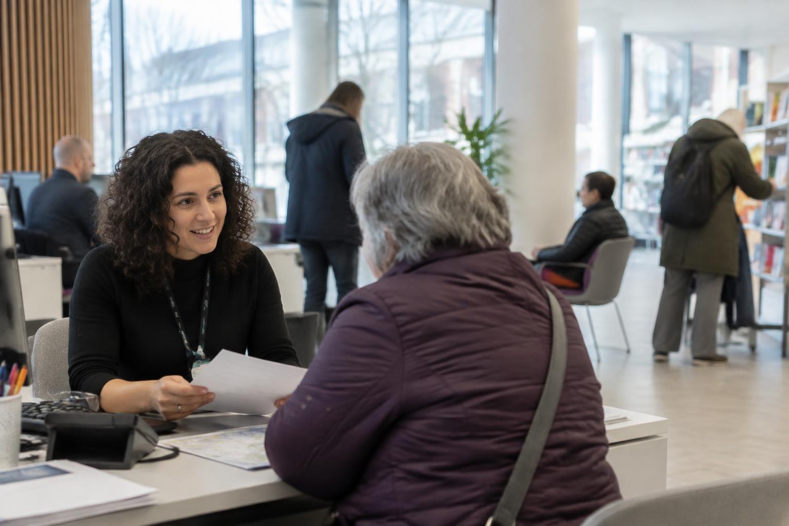 A council adviser helping a resident at a service desk