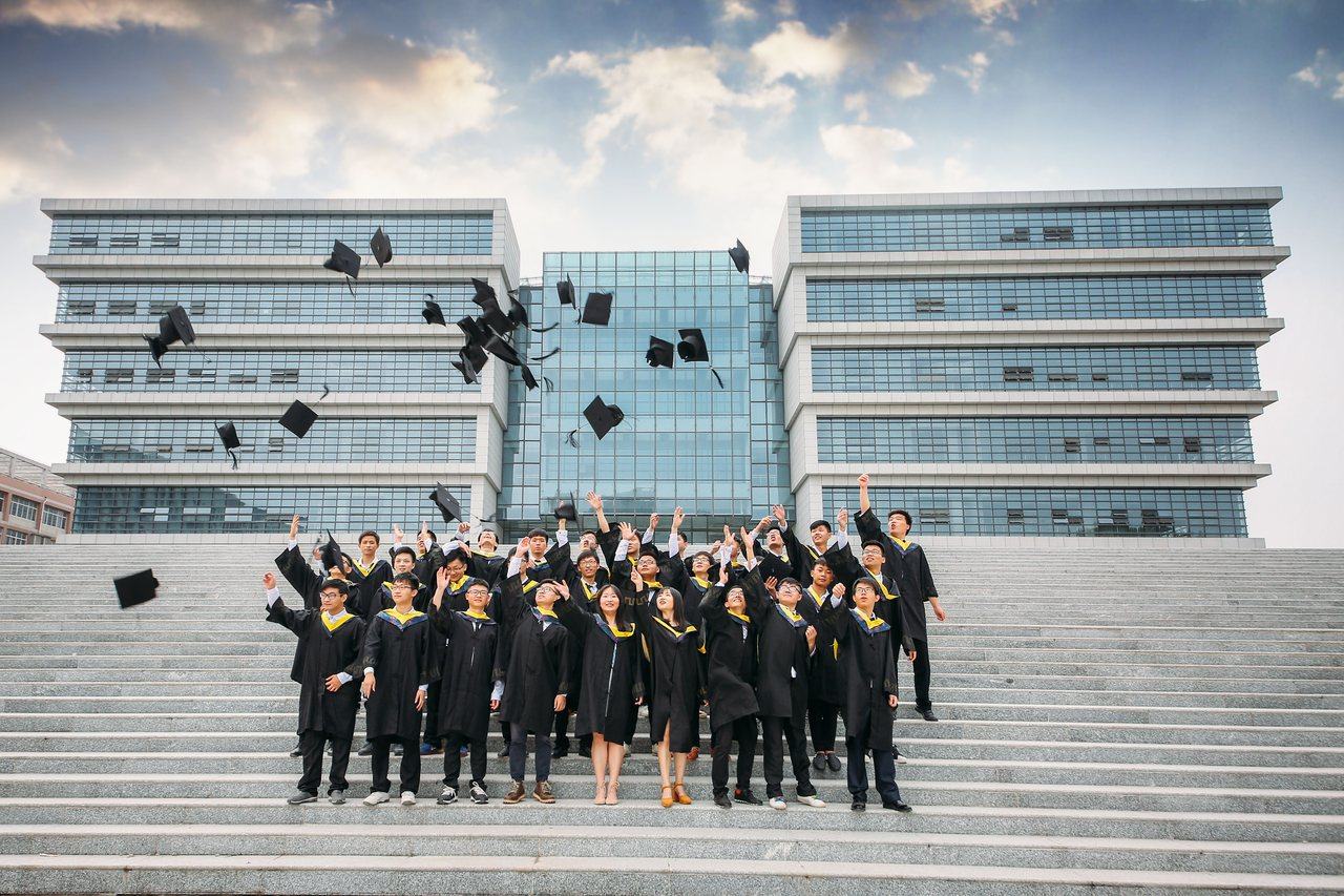 Graduates celebrating outside a university building