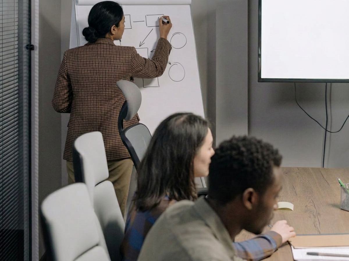 A colleague presenting at a whiteboard in a meeting room